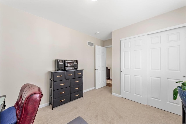 office with baseboards, visible vents, and light colored carpet