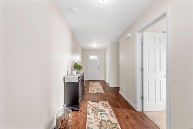 doorway featuring dark wood-style floors and baseboards