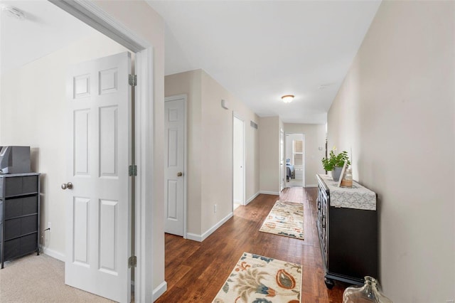 corridor with baseboards and wood finished floors