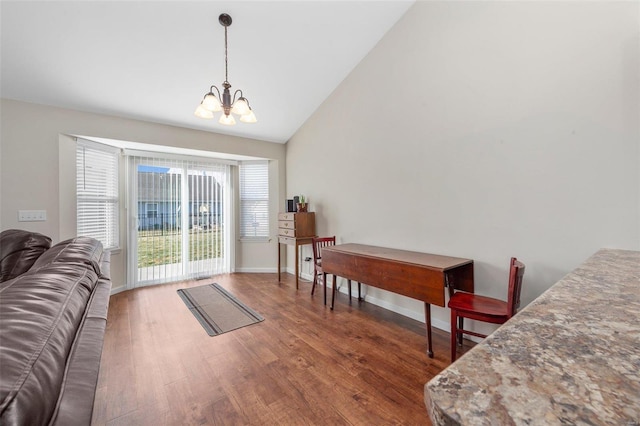 interior space featuring baseboards, high vaulted ceiling, wood finished floors, and a notable chandelier