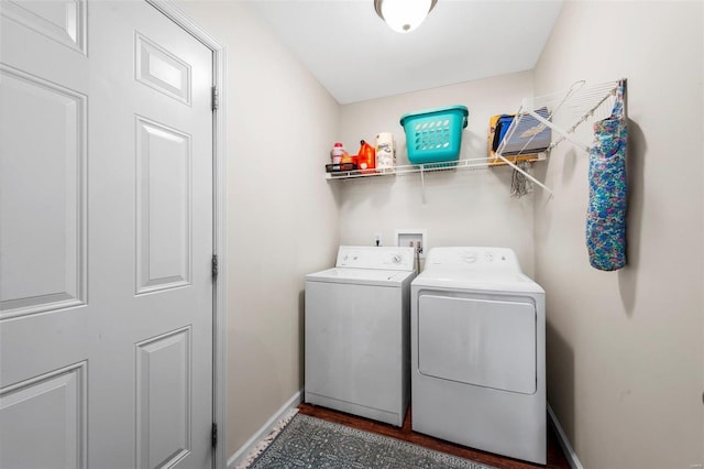 laundry area with laundry area, washing machine and dryer, and baseboards