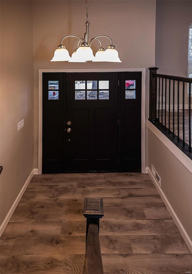 entryway featuring an inviting chandelier, baseboards, visible vents, and dark wood finished floors