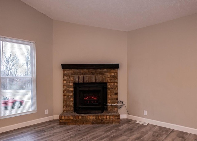 details with a brick fireplace, baseboards, and wood finished floors