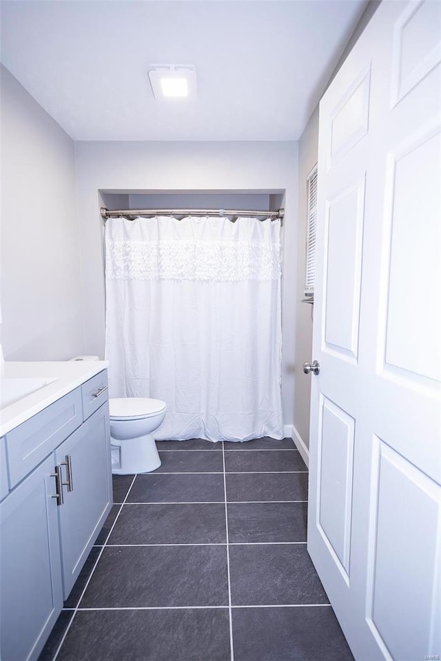 full bathroom with toilet, vanity, and tile patterned floors