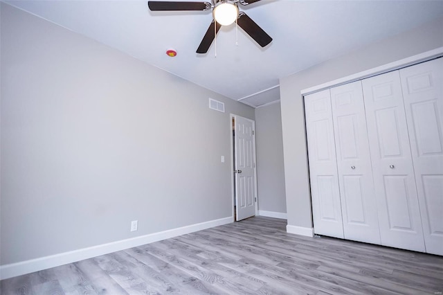 unfurnished bedroom with light wood finished floors, a closet, visible vents, ceiling fan, and baseboards