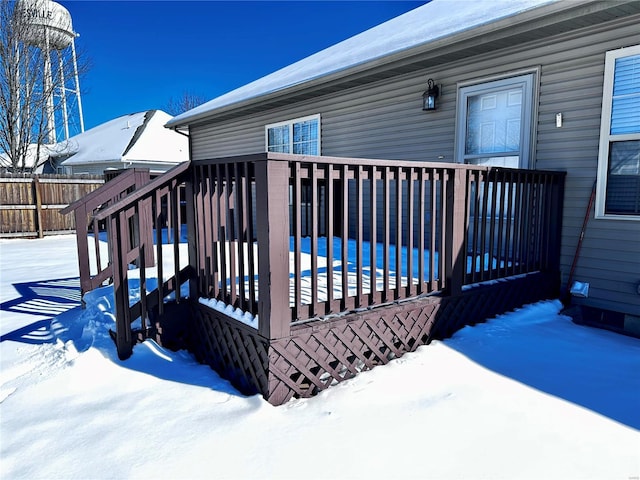 snow covered deck featuring fence