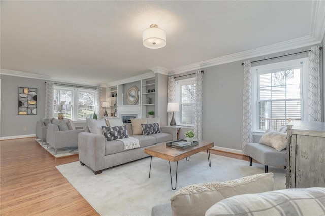 living area featuring light wood-style floors, a wealth of natural light, and ornamental molding