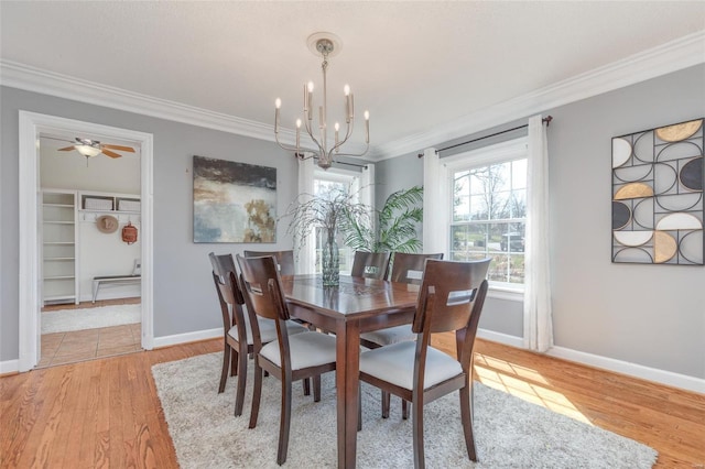 dining room with ceiling fan with notable chandelier, baseboards, light wood-style floors, and ornamental molding