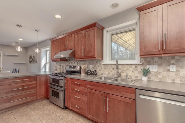 kitchen featuring under cabinet range hood, decorative backsplash, a peninsula, stainless steel appliances, and a sink