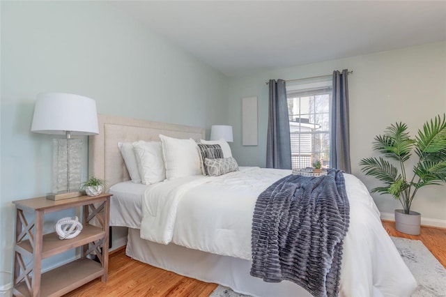 bedroom featuring wood finished floors and baseboards