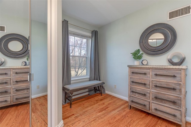 sitting room featuring light wood finished floors, visible vents, and baseboards