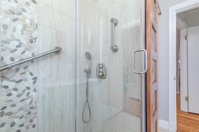 full bathroom featuring a shower stall and wood finished floors