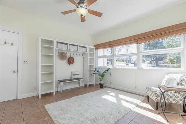 sitting room featuring baseboards, a ceiling fan, and tile patterned flooring