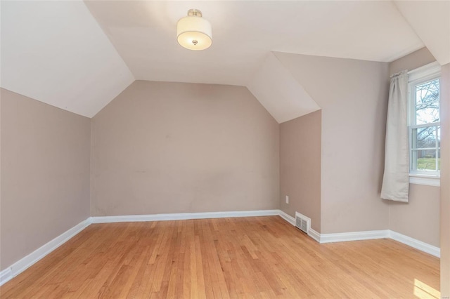 additional living space with baseboards, visible vents, and light wood finished floors