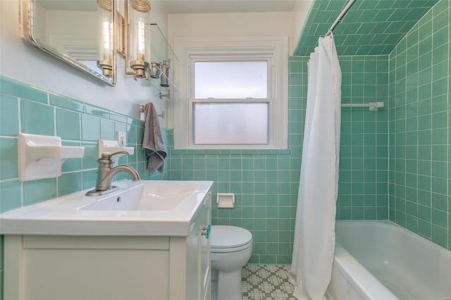 bathroom featuring tile walls, a wainscoted wall, toilet, shower / tub combo with curtain, and vanity