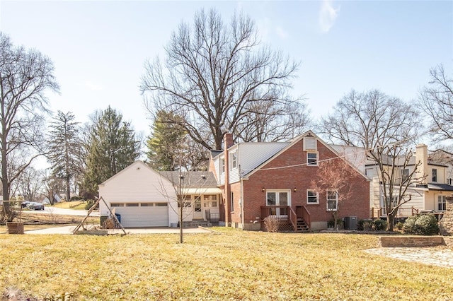 view of front of property with a front yard, a garage, brick siding, and a chimney