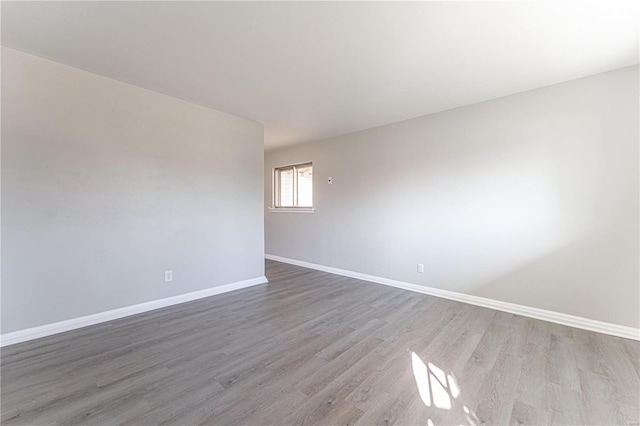 spare room featuring light wood finished floors and baseboards