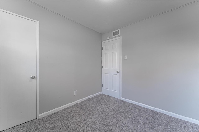 carpeted empty room featuring visible vents and baseboards