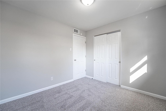 unfurnished bedroom featuring a closet, visible vents, baseboards, and carpet floors