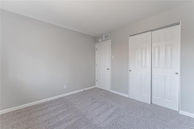 unfurnished bedroom with visible vents, carpet floors, baseboards, and a closet