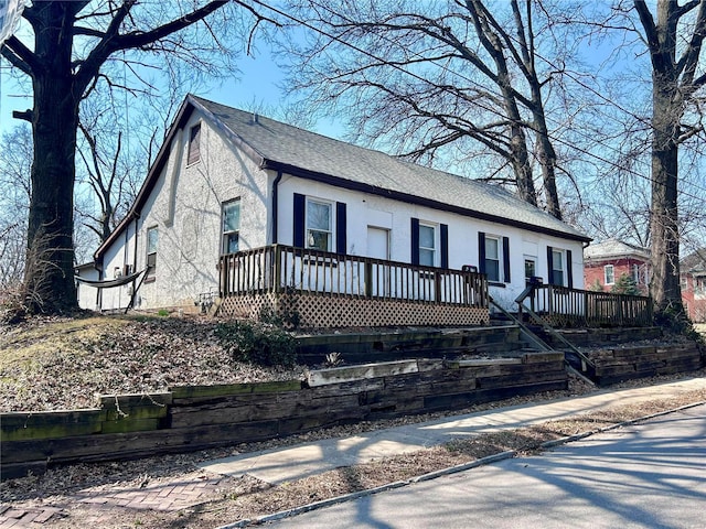 view of front facade featuring stucco siding and a shingled roof