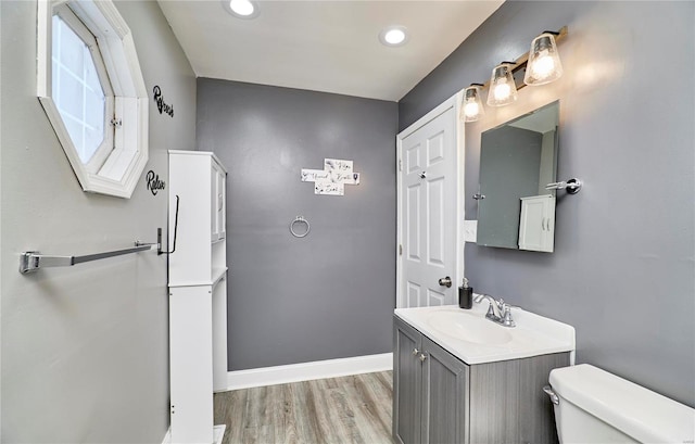 bathroom with vanity, wood finished floors, baseboards, recessed lighting, and toilet