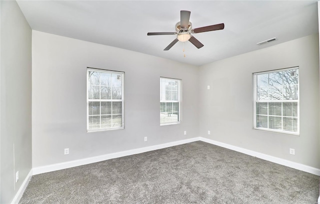 unfurnished room with visible vents, plenty of natural light, and baseboards