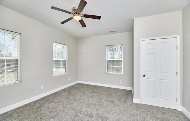 unfurnished bedroom with visible vents, baseboards, a ceiling fan, and carpet flooring