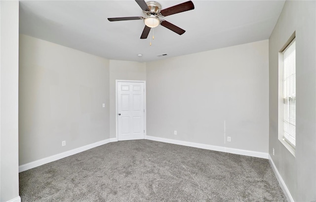 spare room featuring visible vents, baseboards, a ceiling fan, and carpet flooring