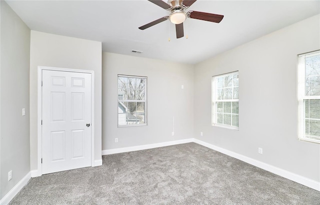 unfurnished bedroom featuring visible vents, baseboards, a ceiling fan, and carpet flooring