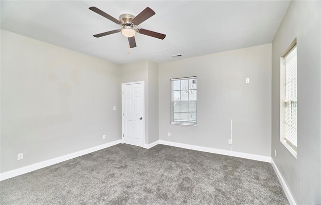 empty room featuring visible vents, ceiling fan, baseboards, and dark colored carpet