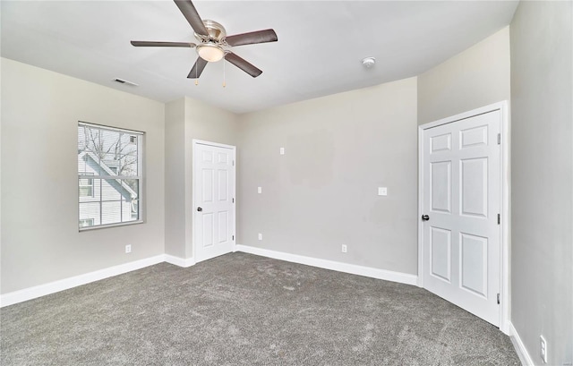 unfurnished bedroom featuring visible vents, baseboards, ceiling fan, and dark carpet