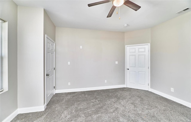 carpeted spare room featuring a ceiling fan, baseboards, and visible vents