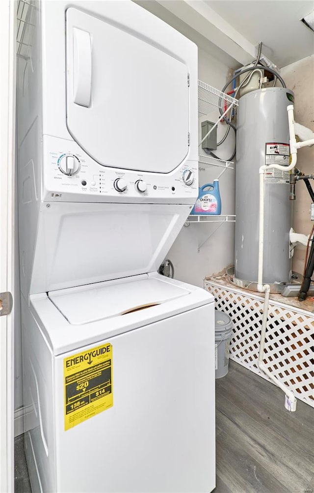 laundry area featuring stacked washer / dryer, electric water heater, laundry area, and wood finished floors