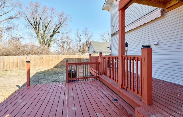 wooden terrace with a fenced backyard