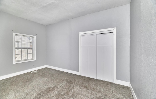 unfurnished bedroom featuring visible vents, baseboards, and carpet