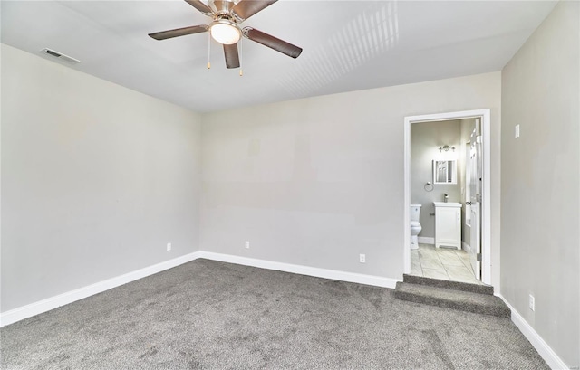 unfurnished room with baseboards, visible vents, a ceiling fan, and carpet