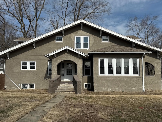 view of front of property featuring a shingled roof, entry steps, and stucco siding