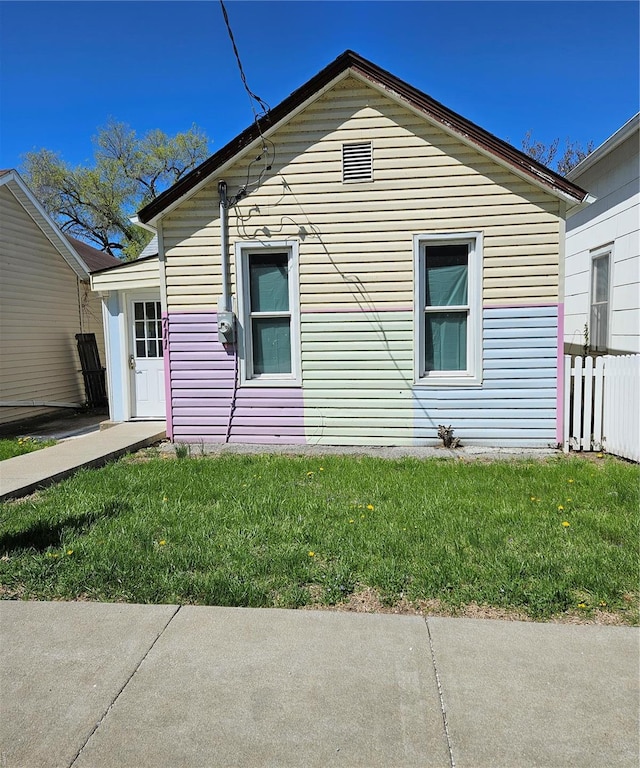 view of side of property featuring a lawn and fence