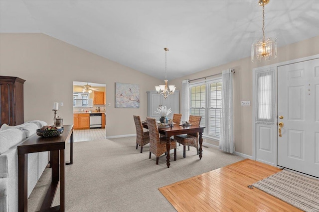 dining space featuring lofted ceiling, light carpet, a notable chandelier, and baseboards