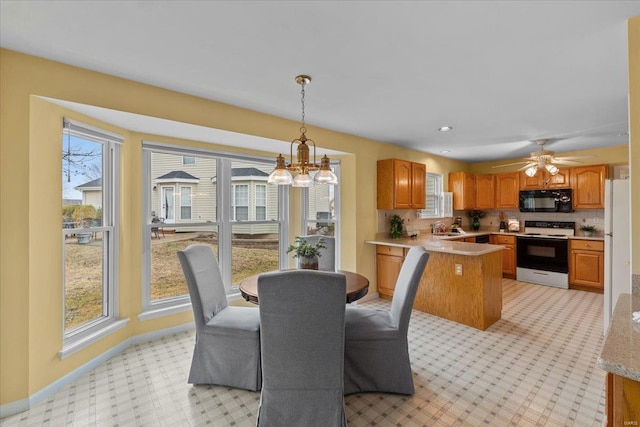 dining room with ceiling fan with notable chandelier, baseboards, and recessed lighting