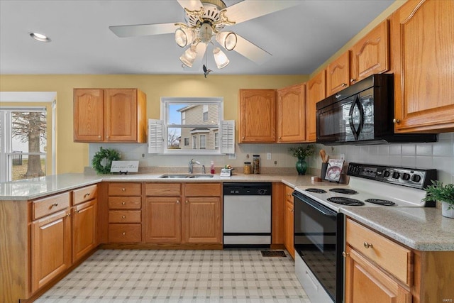 kitchen featuring electric stove, a peninsula, white dishwasher, black microwave, and a sink