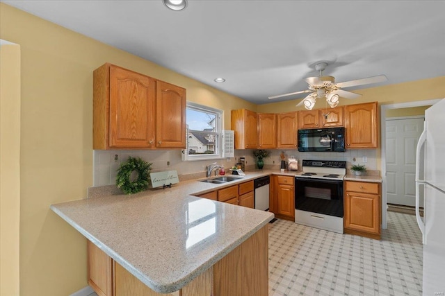 kitchen featuring range with electric cooktop, dishwasher, freestanding refrigerator, black microwave, and a sink