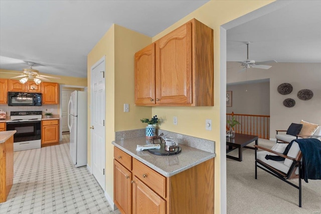 kitchen with a ceiling fan, electric range oven, freestanding refrigerator, light countertops, and black microwave