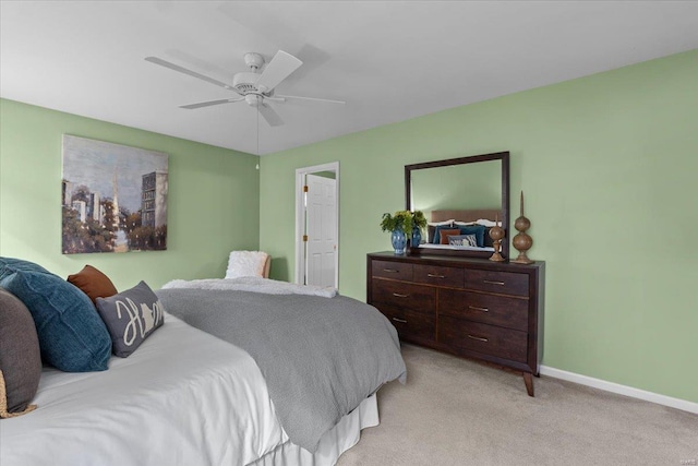 bedroom featuring a ceiling fan, light colored carpet, and baseboards