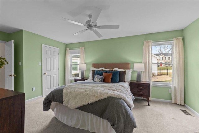 carpeted bedroom with ceiling fan, visible vents, and baseboards