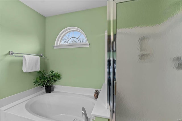 full bath featuring a garden tub and a shower stall