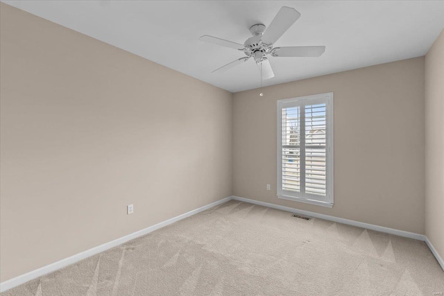 spare room with baseboards, visible vents, ceiling fan, and carpet flooring