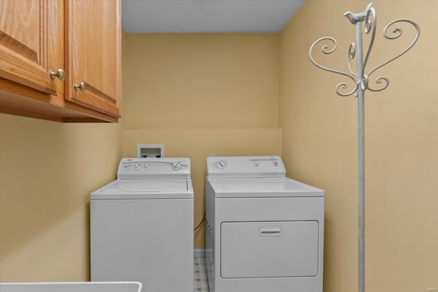 clothes washing area featuring cabinet space and independent washer and dryer