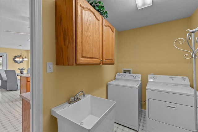 clothes washing area featuring light floors, cabinet space, a sink, and washing machine and clothes dryer